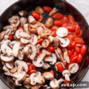 mushrooms and tomatoes in a skillet.