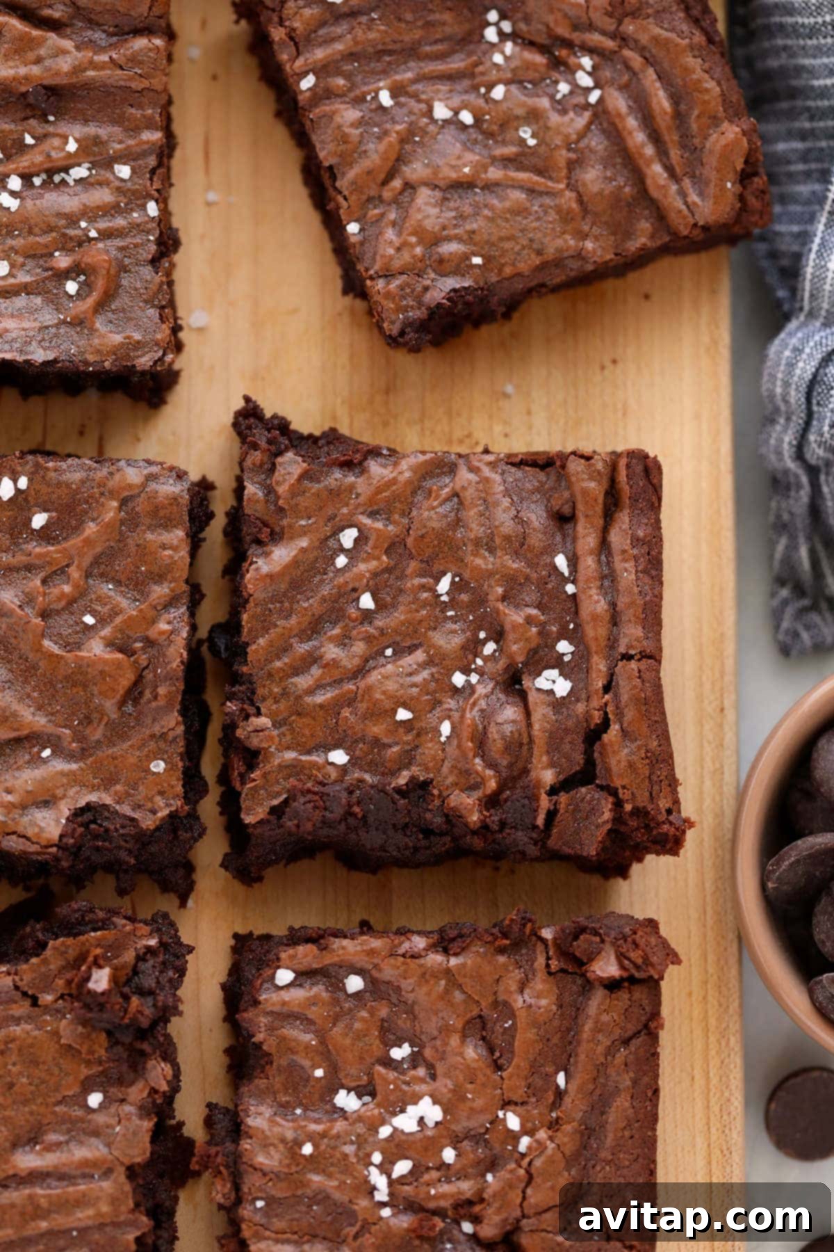 Perfectly baked fudgy brownies on a rustic cutting board, ready to be sliced and enjoyed.