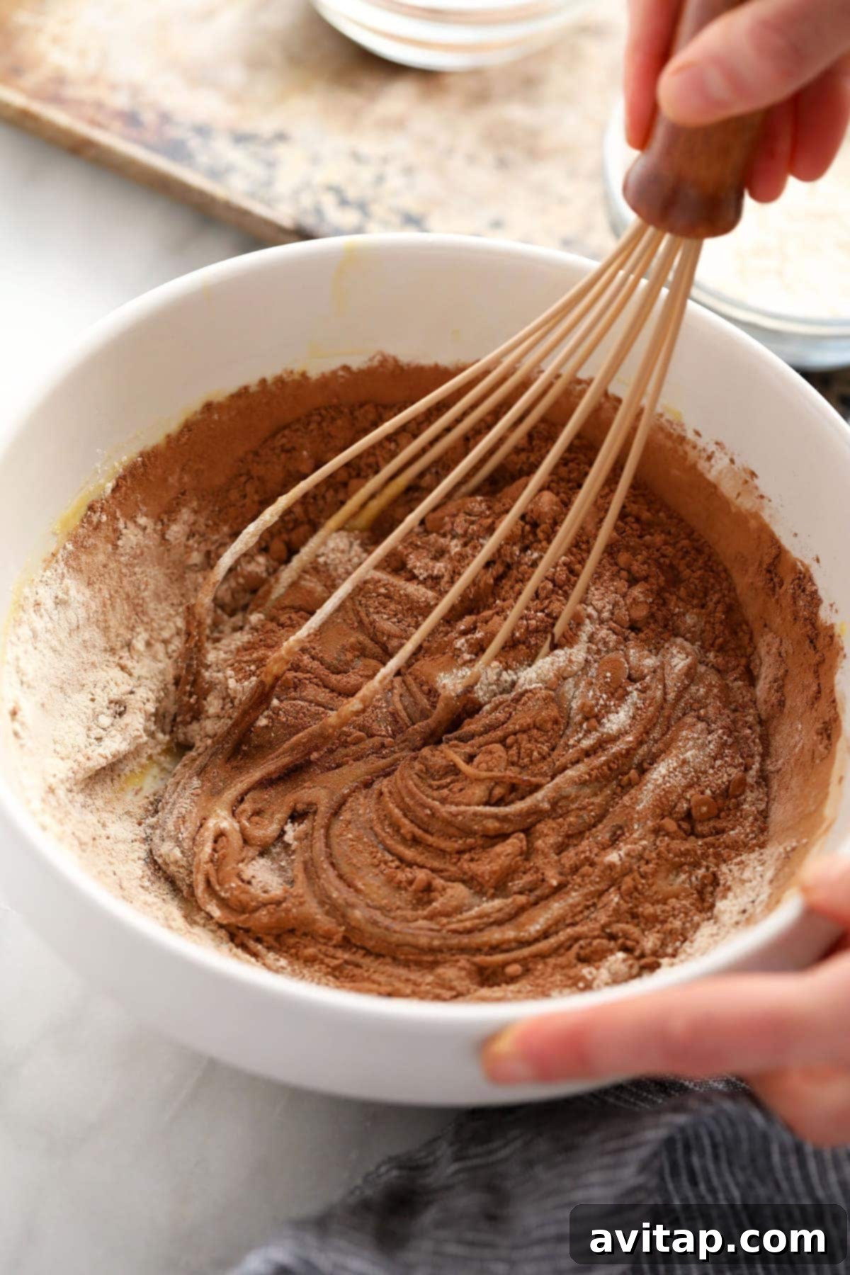 A bowl of flour and cocoa powder being whisked together, a crucial step for achieving perfect fudgy brownies.