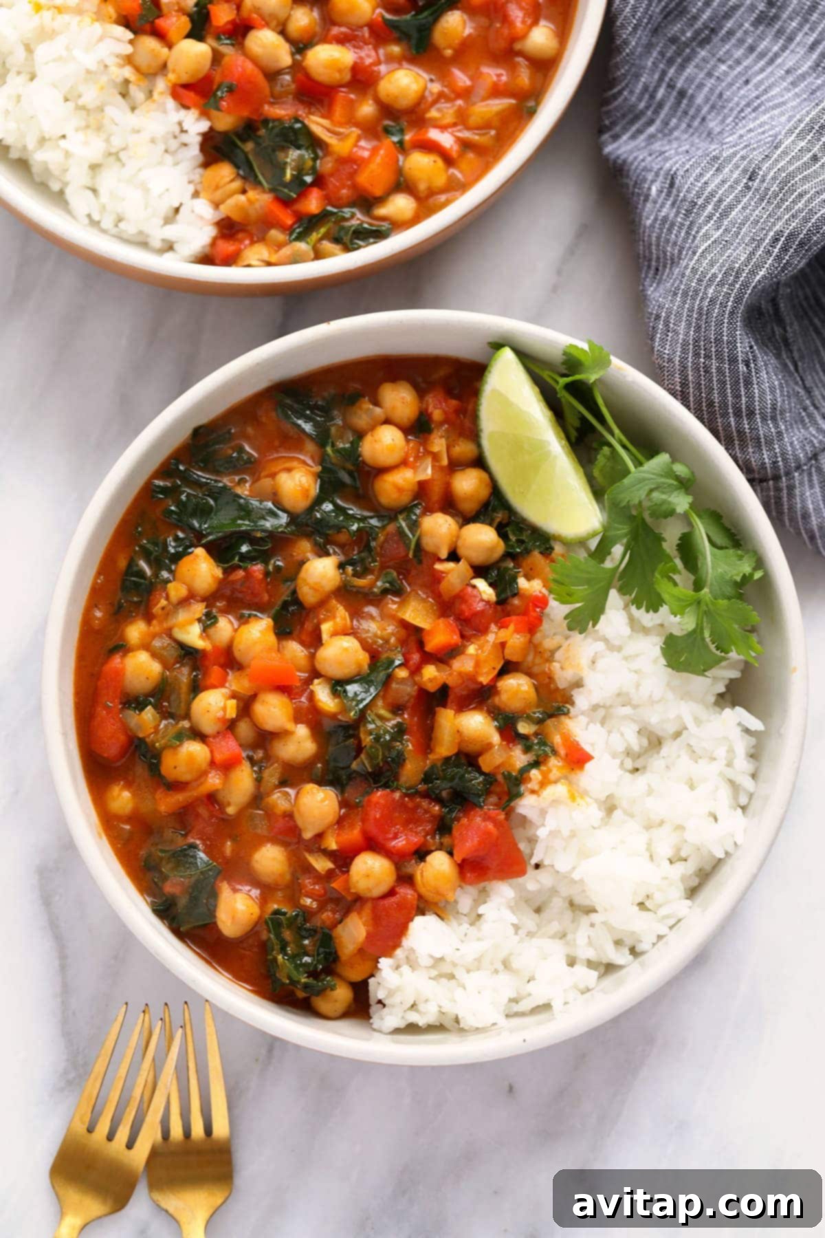Delicious One-Pot Chickpea Curry with Rice A vibrant bowl of chickpea curry served alongside a portion of fluffy white jasmine rice, garnished with fresh cilantro.