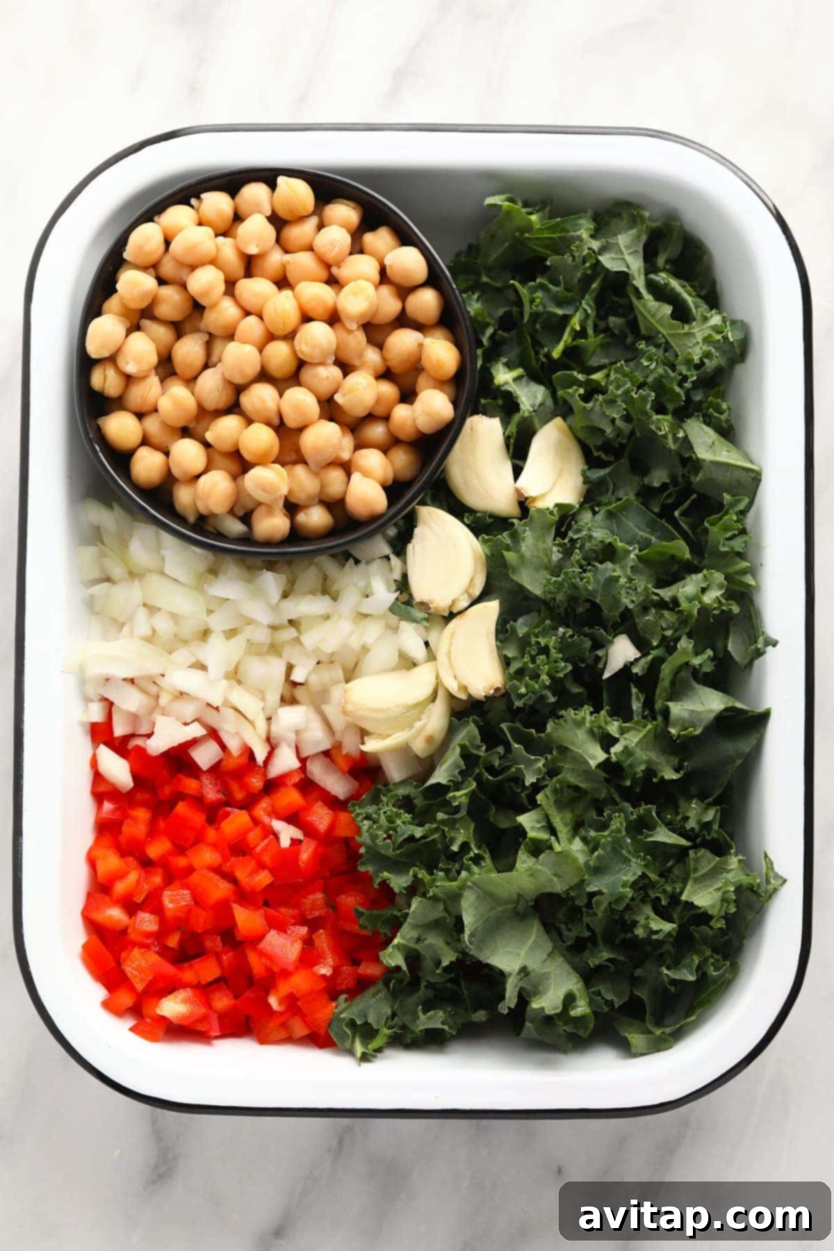 Fresh and Vibrant Ingredients for Chickpea Curry Fresh ingredients for a healthy chickpea curry, including chickpeas, kale, red bell peppers, onions, ginger, and various spices, neatly arranged on a wooden board, ready for cooking in a Dutch oven.