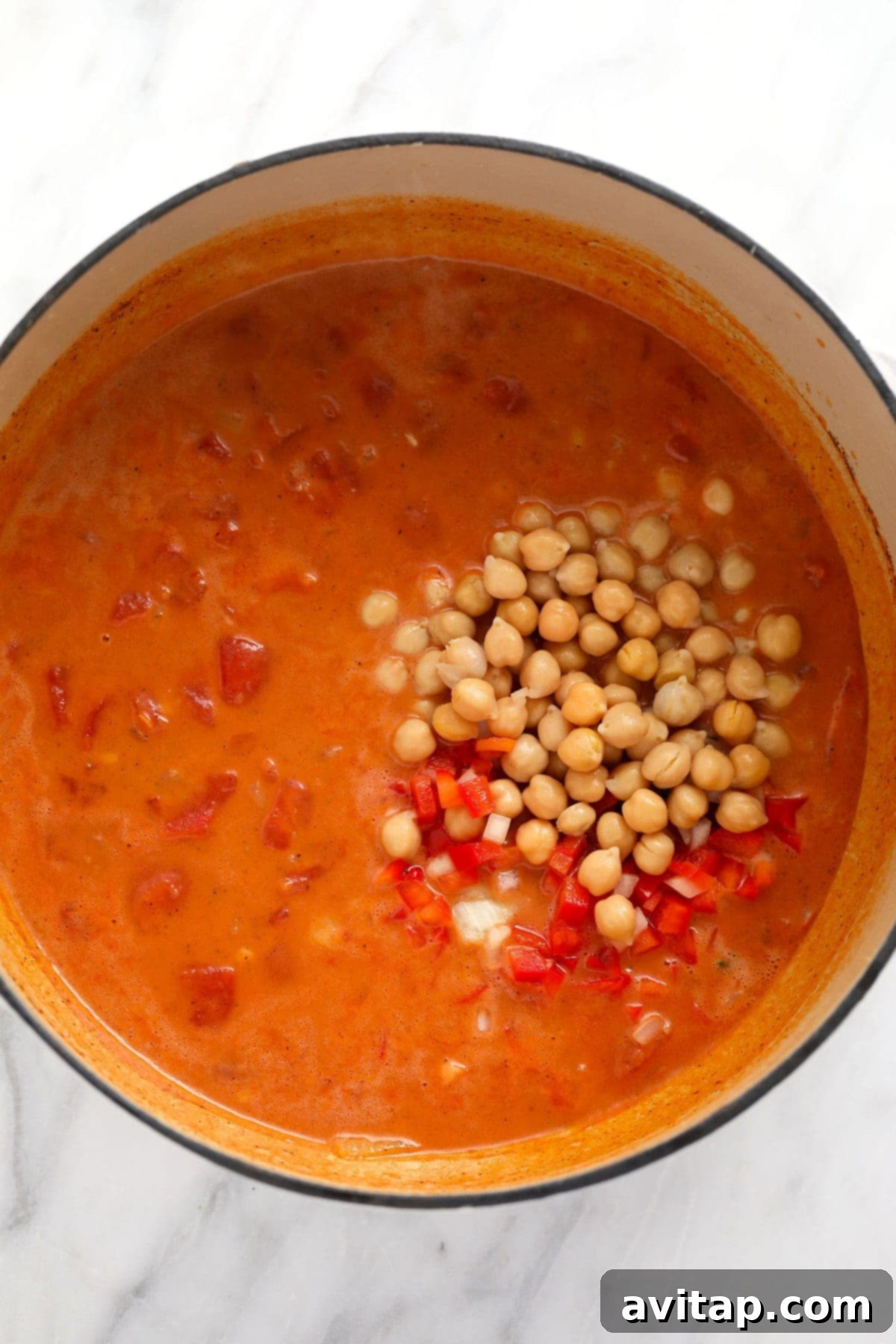 Chickpea Curry Sauce Simmering The rich, creamy chickpea curry sauce simmering to perfection in a classic Dutch oven, prior to the final addition of fresh greens.