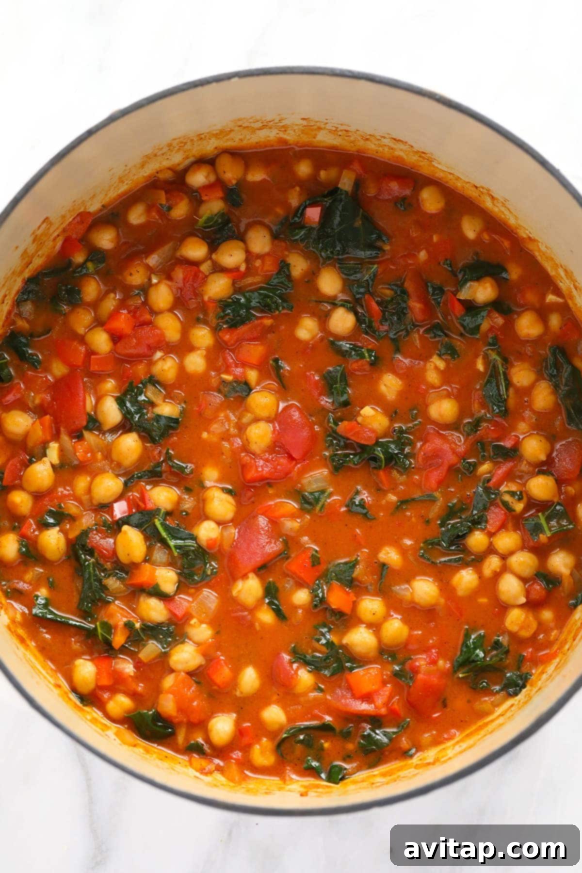 Finished One-Pot Chickpea Curry, Ready to Enjoy A full Dutch oven displaying a freshly cooked batch of chickpea curry, vibrant with colorful vegetables and a rich, golden sauce, perfectly ready to be served.
