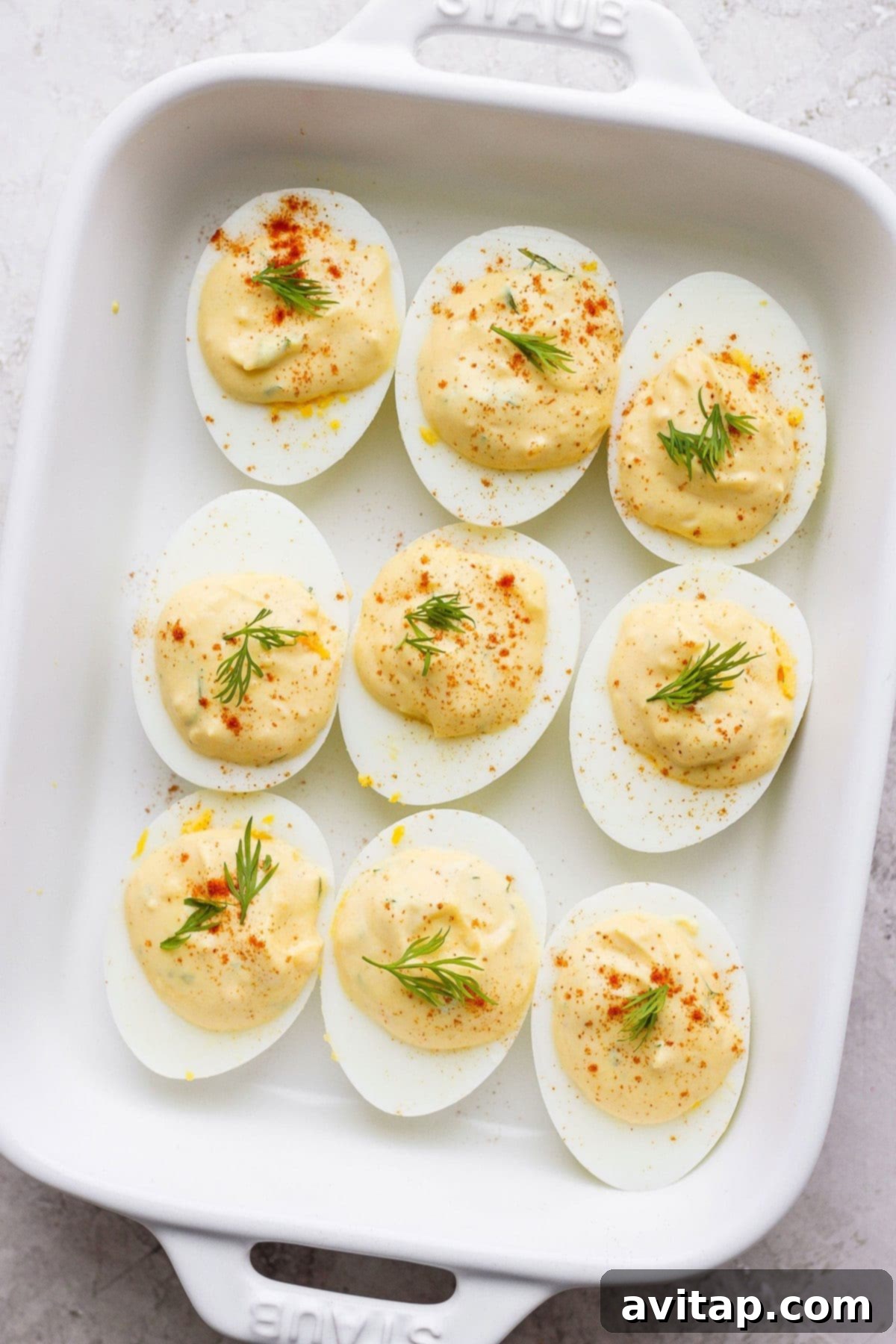 easy deviled eggs in a dish garnished with paprika and fresh dill