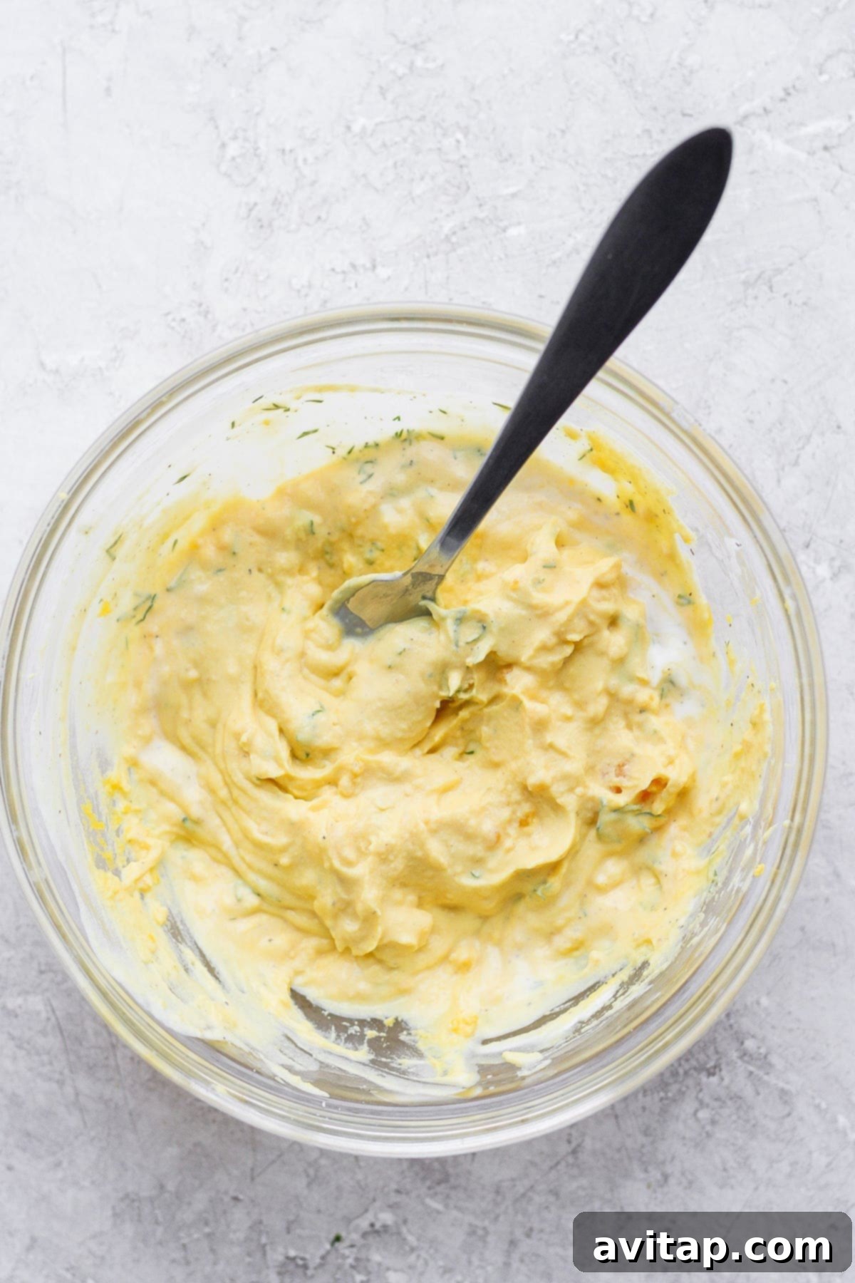 easy deviled eggs filling mixed together with a spoon in a bowl