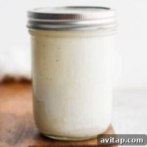 A jar of white liquid, smoothly mixed, representing the finished dressing.