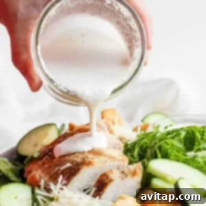 A person pouring a dressing over a salad.