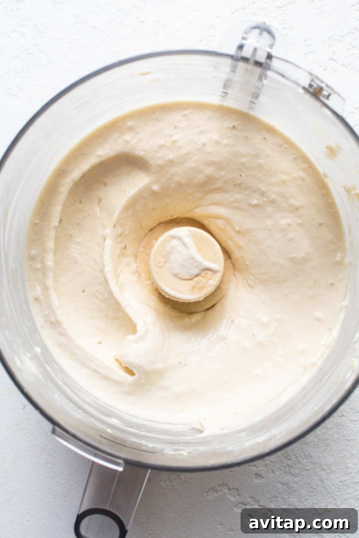 A blender with a white substance in it, indicating the blending process of nice cream.