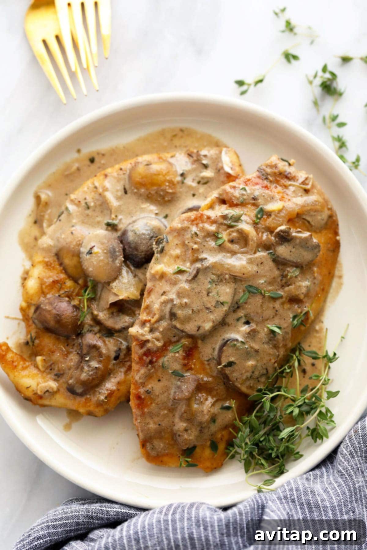 Golden-brown pan-seared chicken marsala with creamy mushroom sauce on a white plate