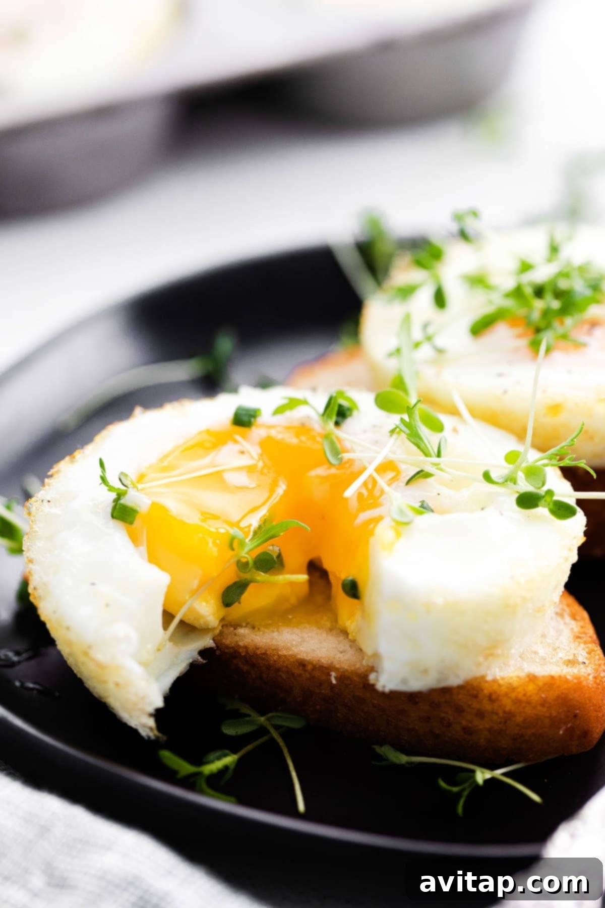 A perfectly baked egg with a slightly runny yolk, served on a slice of toasted bread.