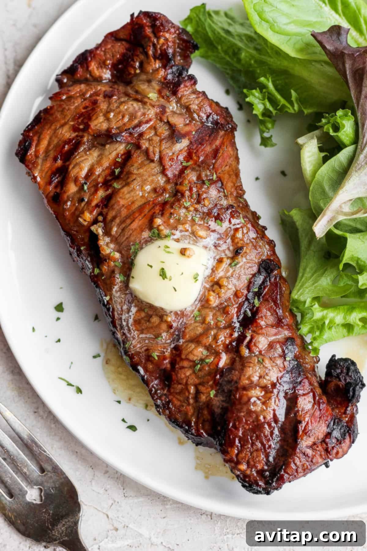 A perfectly cooked, juicy steak on a plate, showcasing the rich flavors infused by the marinade.