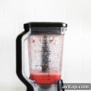 a blender filled with a strawberry smoothie.