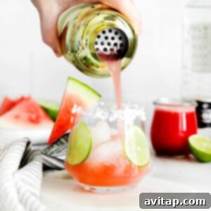 a person pouring watermelon into a margarita glass.