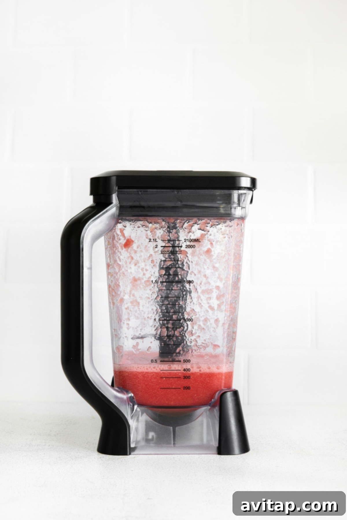 The result of blending, a smooth and vibrant fresh watermelon juice inside a blender, ready for the next step of margarita preparation.