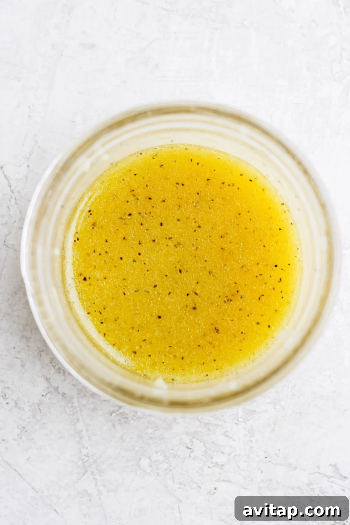 Fresh lemon vinaigrette prepared and ready in a small mason jar, showcasing its vibrant color.