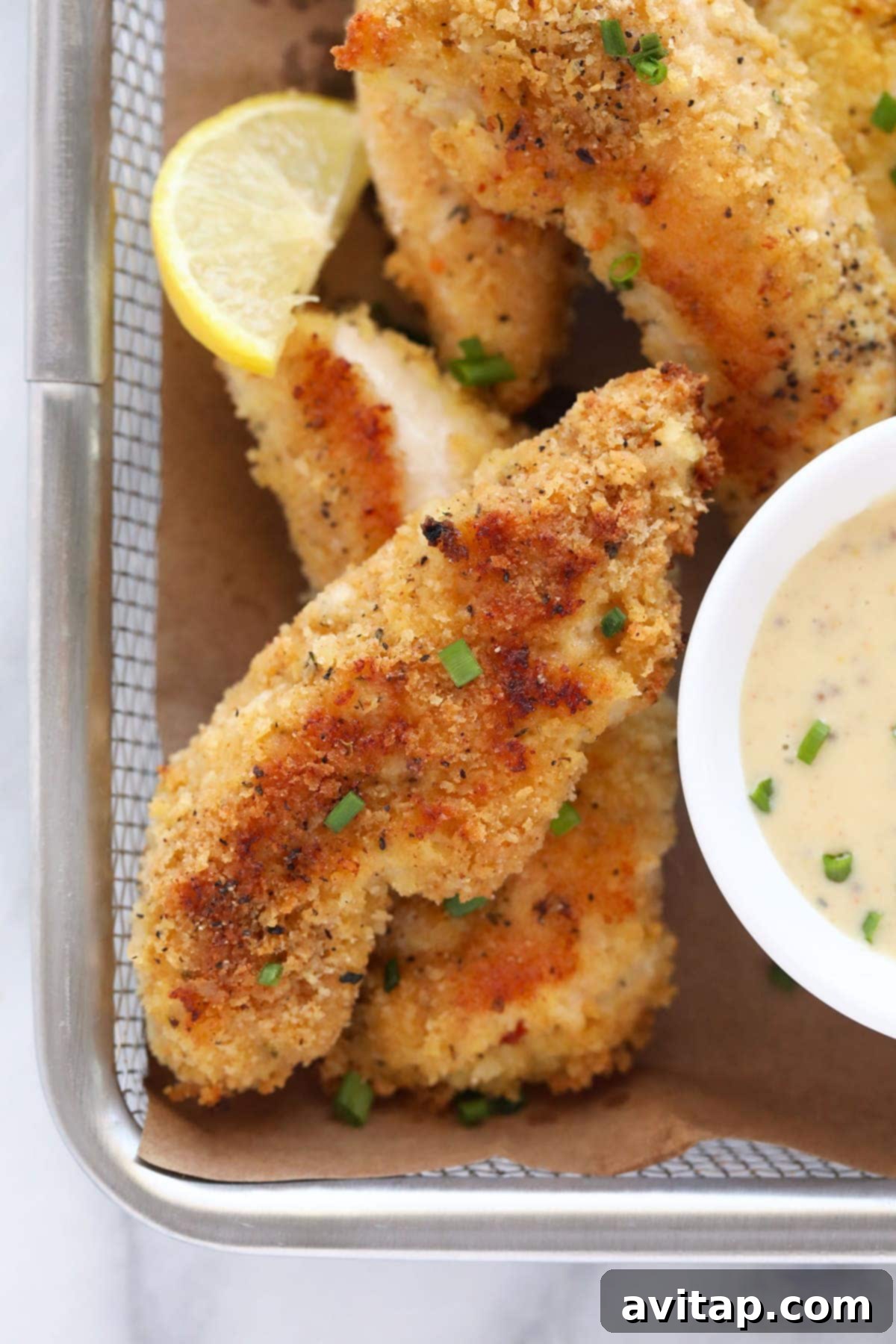 Golden Baked Chicken Fingers 8 A basket full of golden-brown, crispy baked chicken tenders, ready to be served.