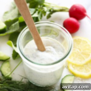 The finished creamy Greek yogurt dill dressing presented in a clear glass jar, showing its delightful texture and fresh dill.