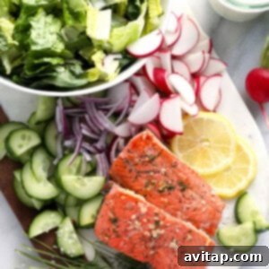 Freshly chopped salad ingredients including radishes, cucumbers, and lettuce, laid out and ready for assembly.