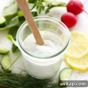 Homemade Greek yogurt dressing in a jar, showcasing its inviting creamy texture and fresh ingredients like dill and lemon.