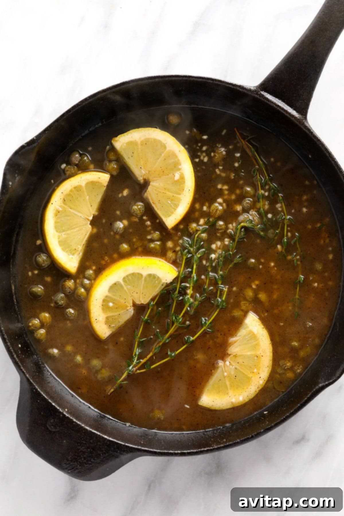 Zesty Lemon Caper Salmon 6 A vibrant piccata sauce bubbling in a pan, infused with fresh lemon slices, thyme sprigs, and briny capers.