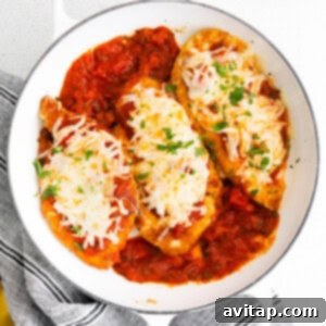 Baked chicken parmesan in a casserole dish, cheese melted.