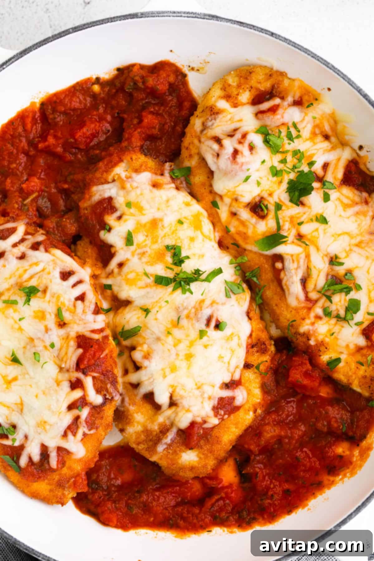 chicken parmesan with cheese and basil on noodles.