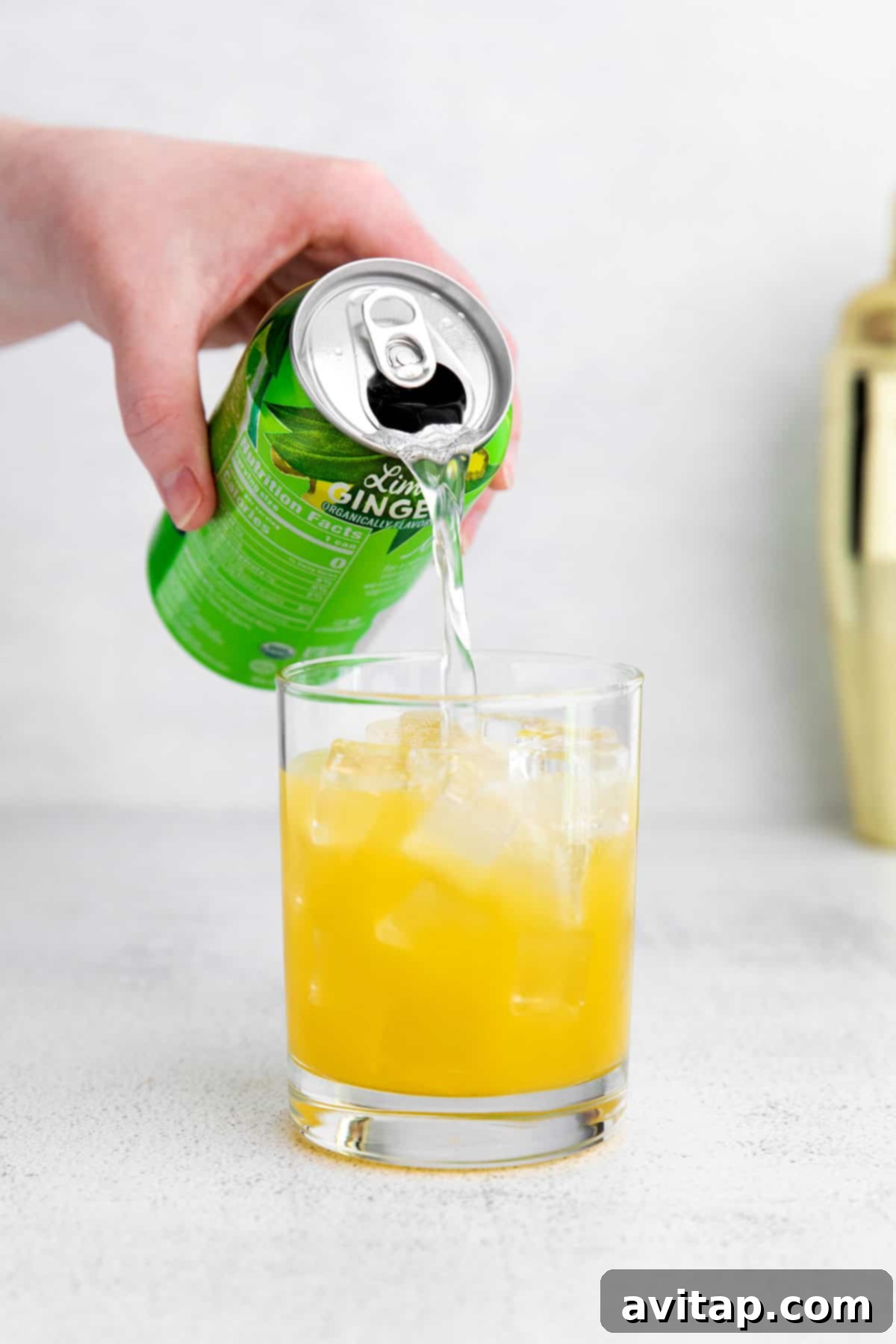 pouring sparkling water into a virgin margarita.