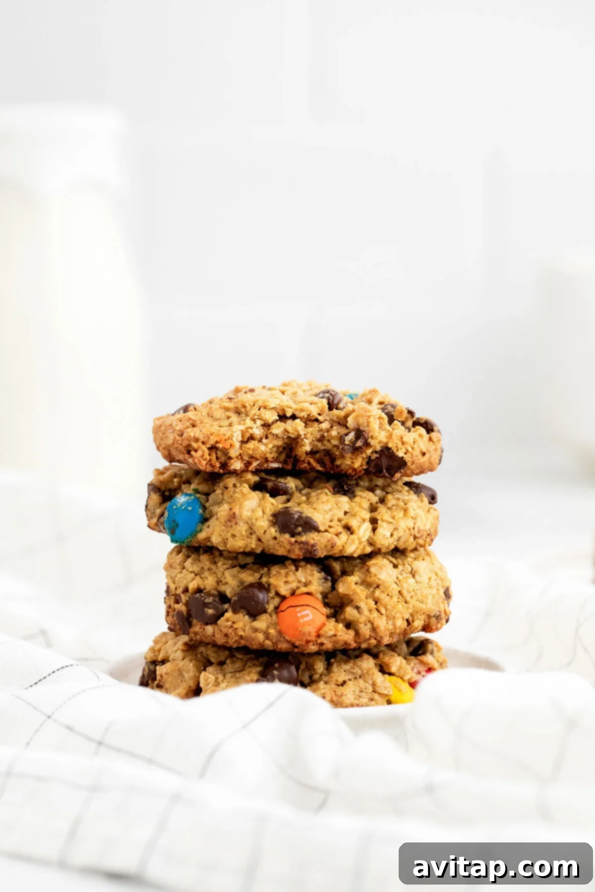 A mouth-watering stack of freshly baked monster cookies, perfect for sharing (or not!). Generous stack of flourless monster cookies on a cooling rack, showcasing their irresistible appeal and vibrant mix-ins.