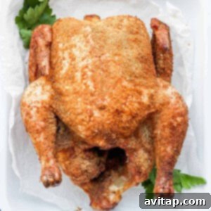 A whole smoked chicken beautifully presented in a pan, ready to be carved and served.