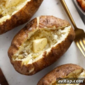 Smoked baked potatoes, split open and ready to be served with butter and a variety of delicious toppings.