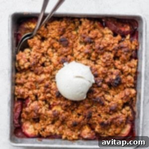 The Ultimate Peach Crisp 5 Freshly baked peach crisp, golden brown and bubbly, topped with a scoop of vanilla ice cream, served directly in the baking dish for a rustic presentation.