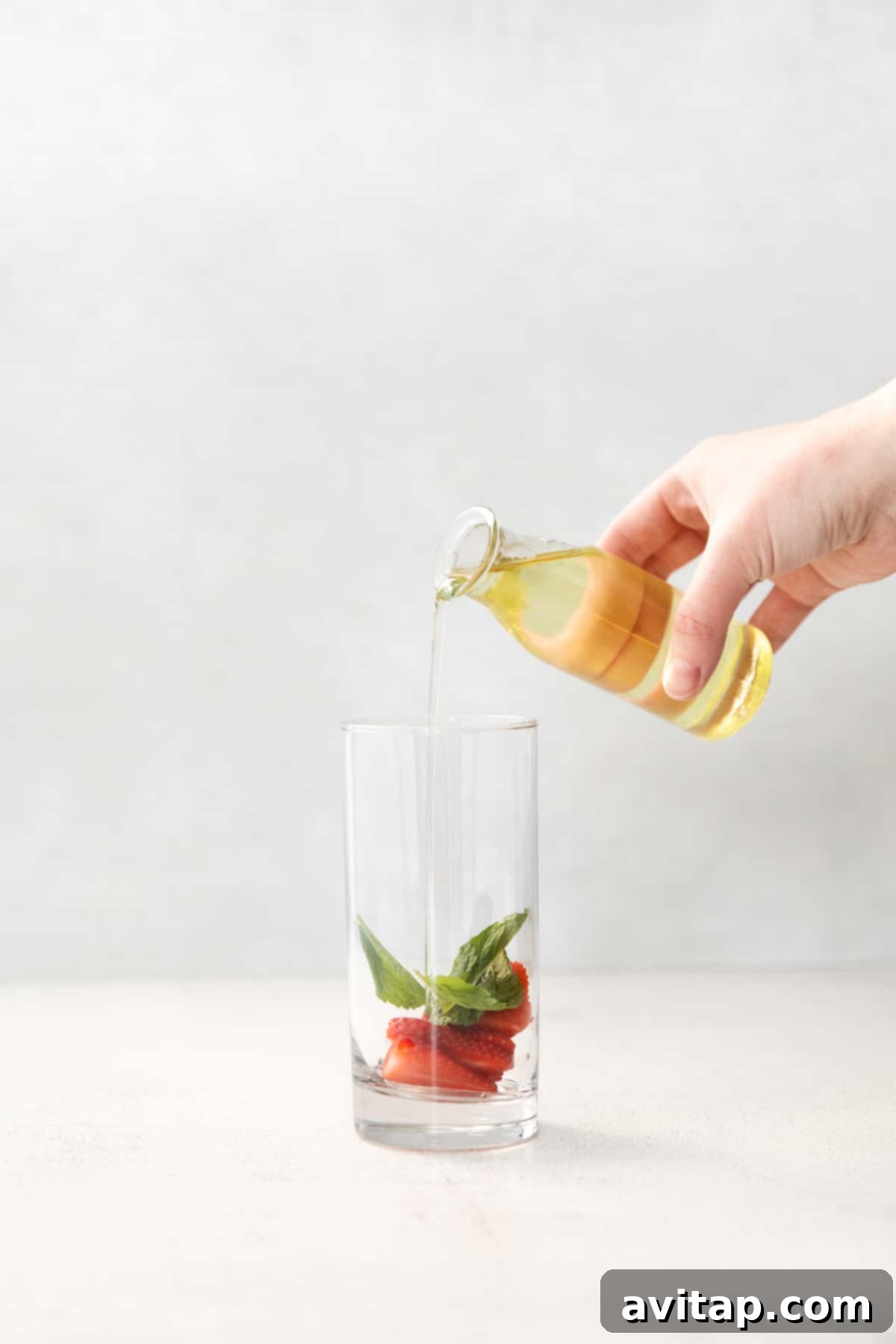 Pouring homemade simple syrup into a glass