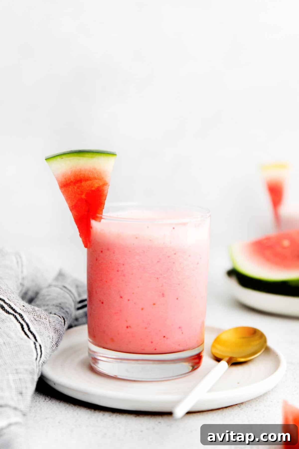 A close-up of a refreshing watermelon smoothie in a glass, with a hint of foam on top.