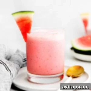 A refreshing watermelon smoothie in a glass, garnished with a small piece of fresh watermelon.