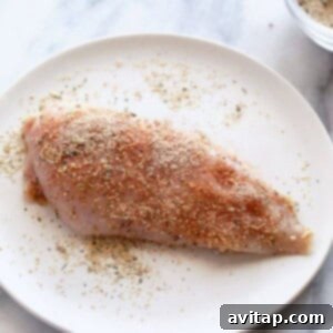 Golden Crispy Bacon Wrapped Chicken 3 A piece of chicken on a plate with spices on it.