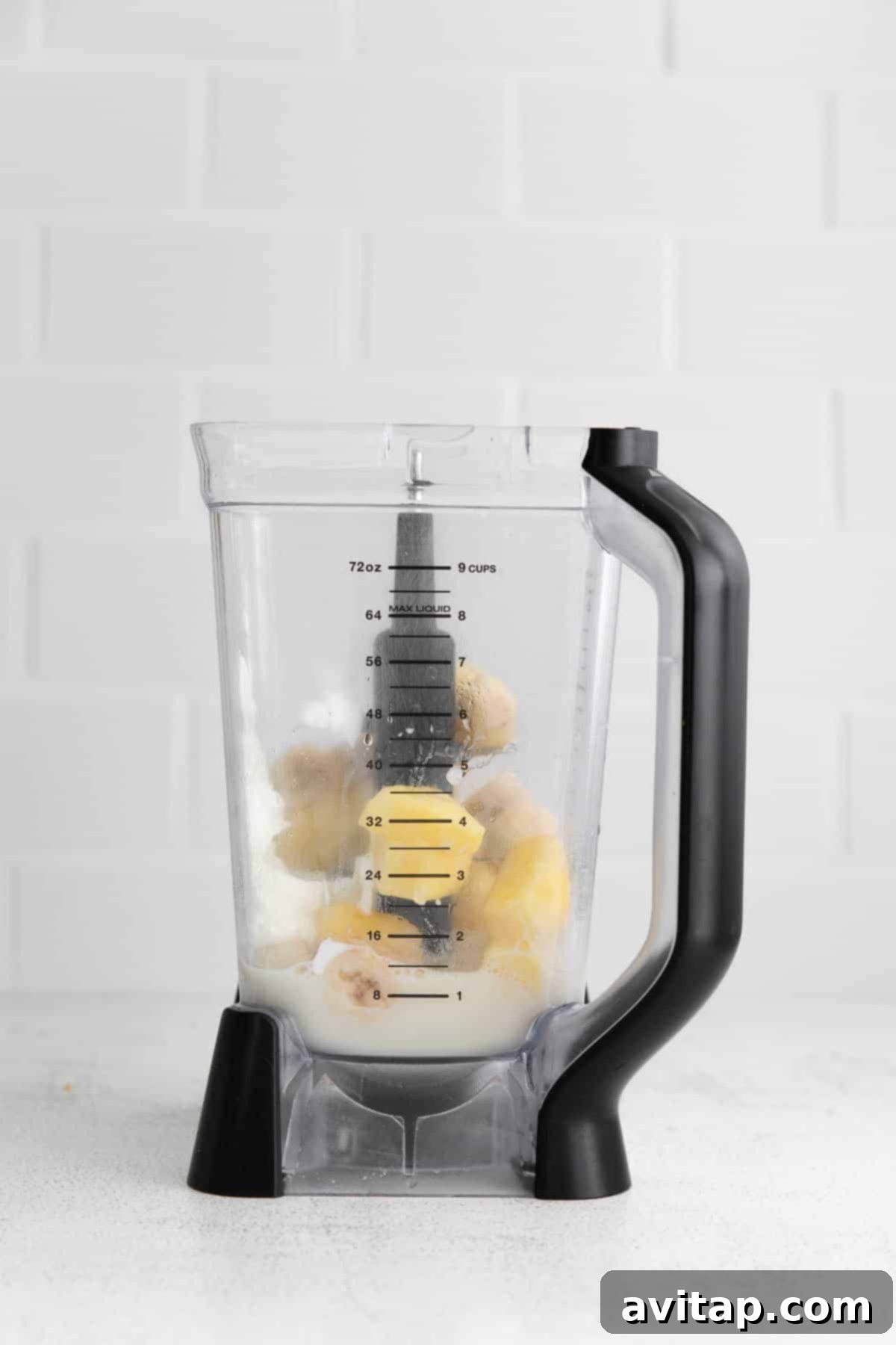 All the pineapple smoothie ingredients are placed inside a high-speed blender, ready to be transformed into a delicious drink.