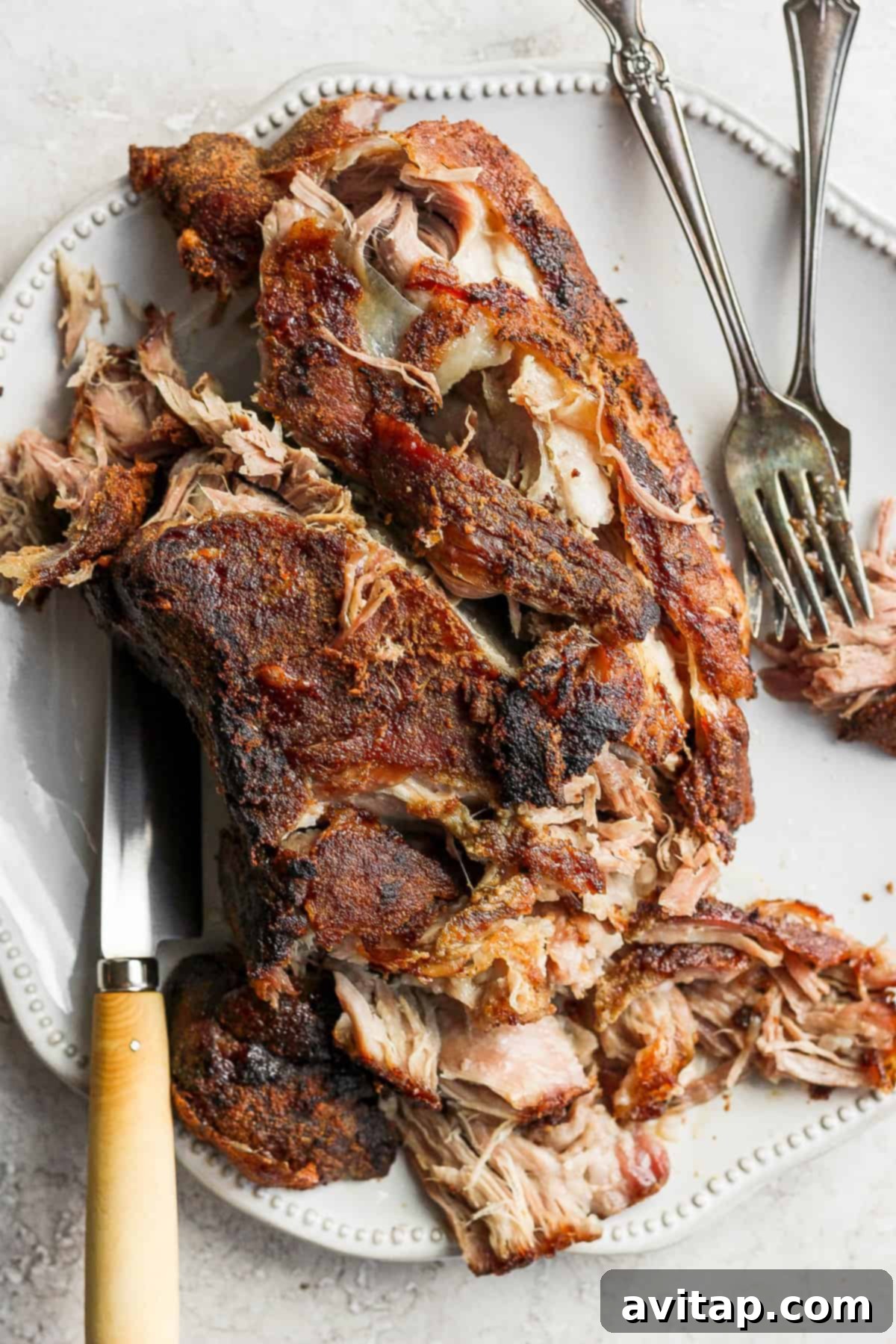 Slow Roasted Pork Shoulder: Tender, Juicy, and Crispy Perfection A platter of beautifully shredded slow-roasted pork shoulder with crispy edges, ready to be served.