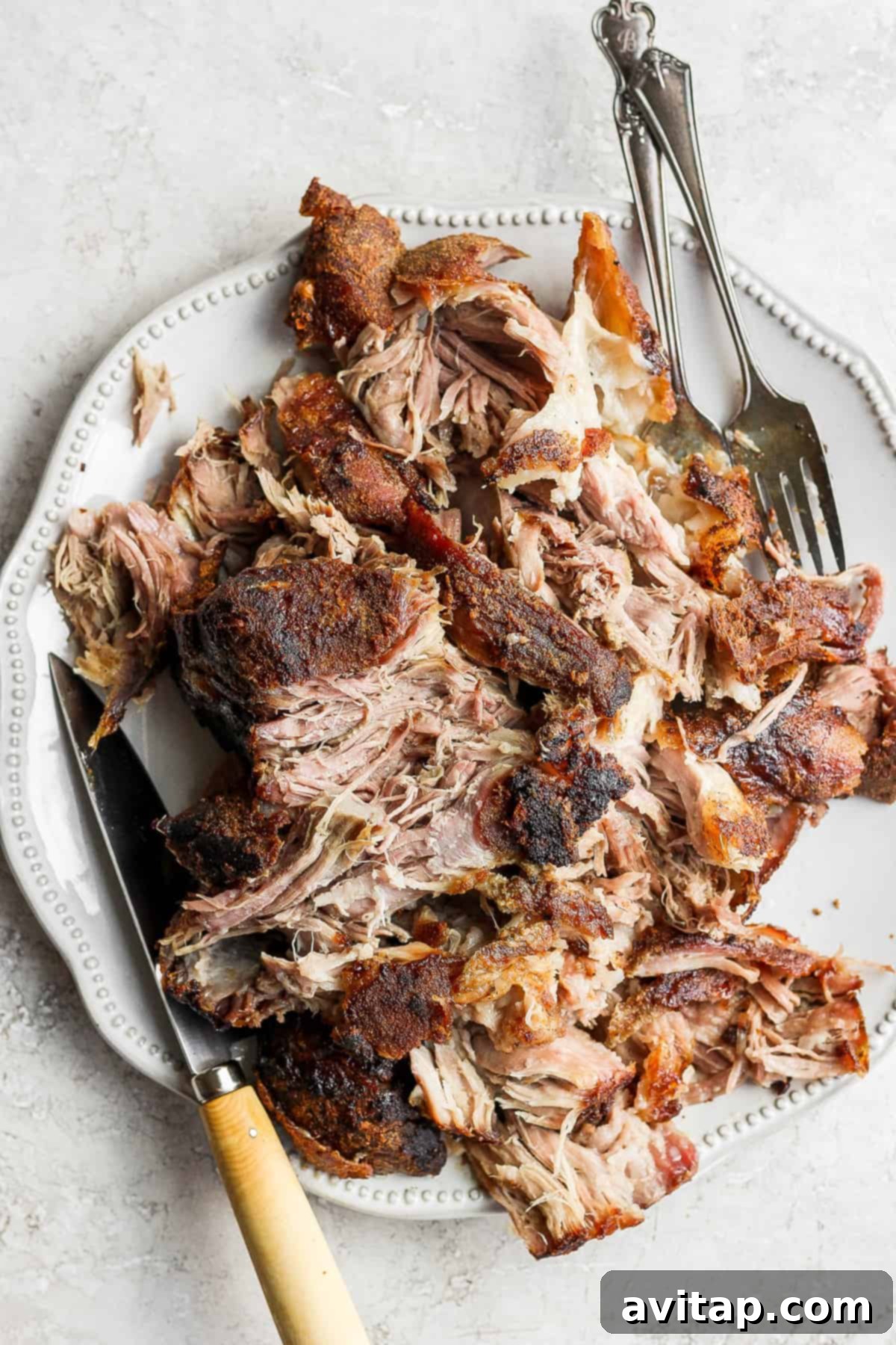 The Ultimate Platter of Shredded Pork Shoulder A generous serving of shredded slow-roasted pork shoulder on a large platter, garnished and ready for a family meal.