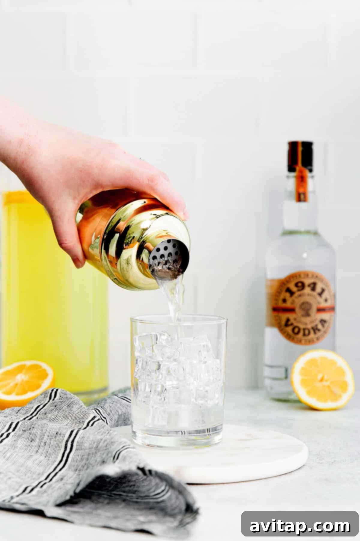 Pouring a vibrant vodka lemonade into a tall glass, ready for enjoyment.