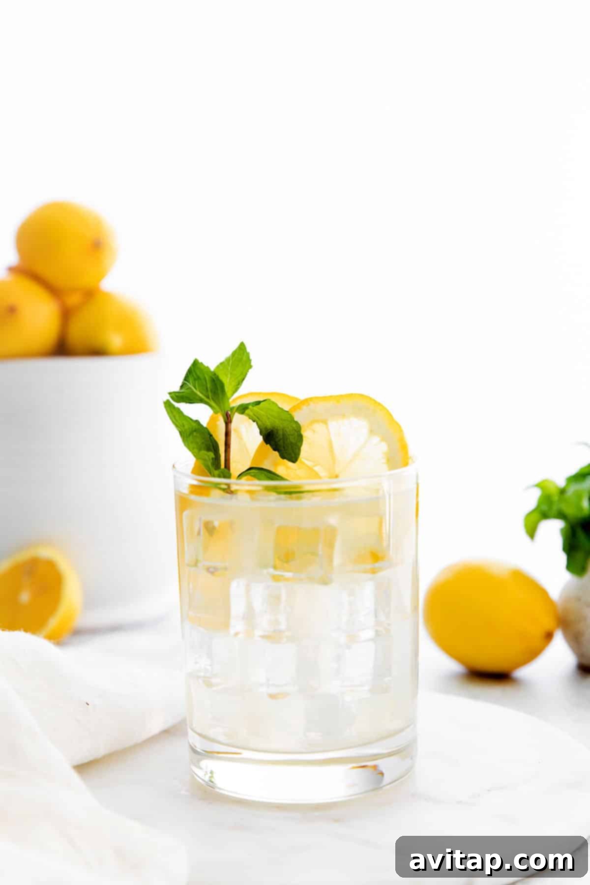 Close-up of a clear glass filled with refreshing vodka lemonade and ice.