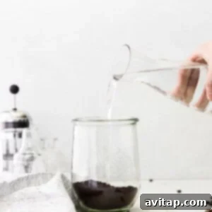 Pouring water over coffee grounds to make cold brew coffee.