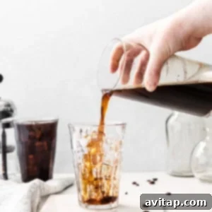 Pouring cold brew coffee into a glass with ice.