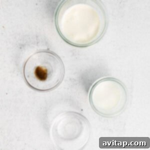 Three glass bowls displaying milk, sugar, and butter, representing key ingredients for sweet cream preparation.