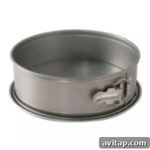 A sturdy metal springform pan, ideal for baking cheesecakes, complete with a convenient handle for easy maneuvering.