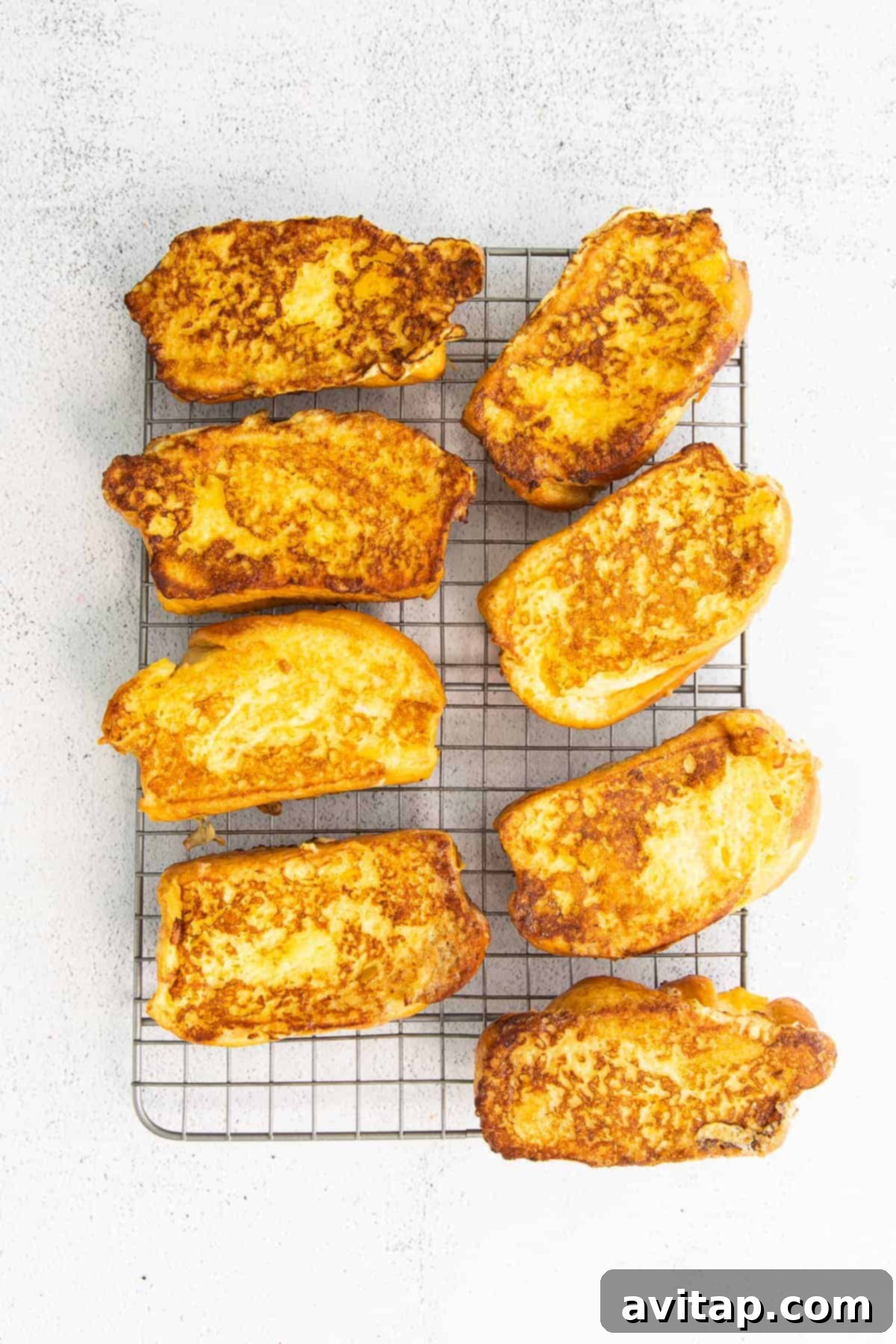 Freshly cooked French toast cooling on a wire rack, ready for serving.