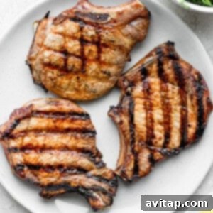 Grilled pork chops on a plate, showcasing a perfect sear and inviting aroma, ready to be served.