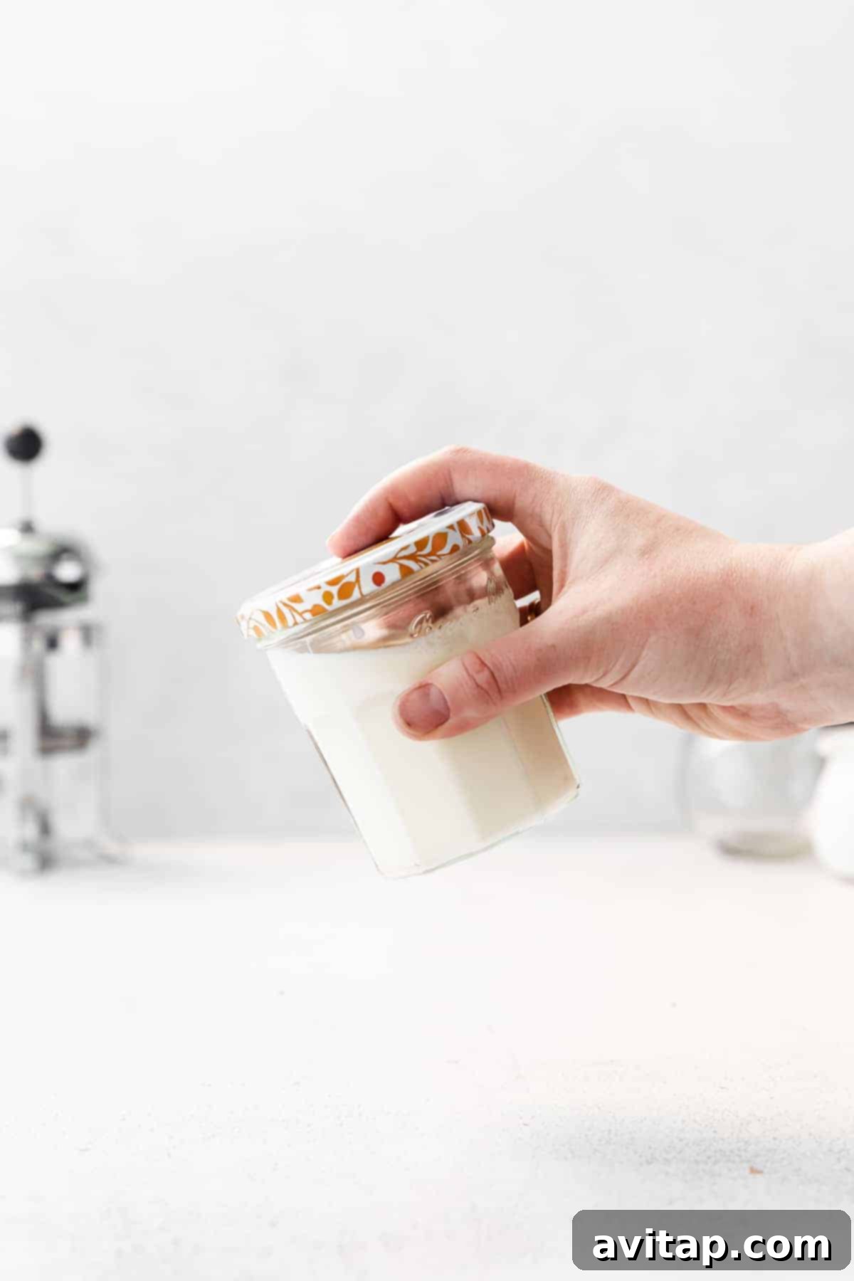 Shaking vanilla sweet cream in a jar to combine ingredients.
