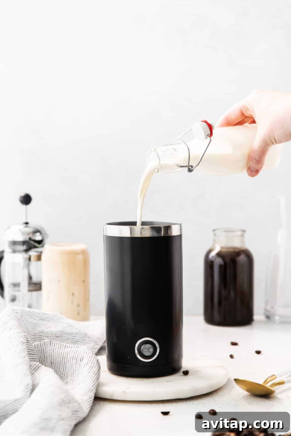 Pouring vanilla sweet cream into an electric frother.