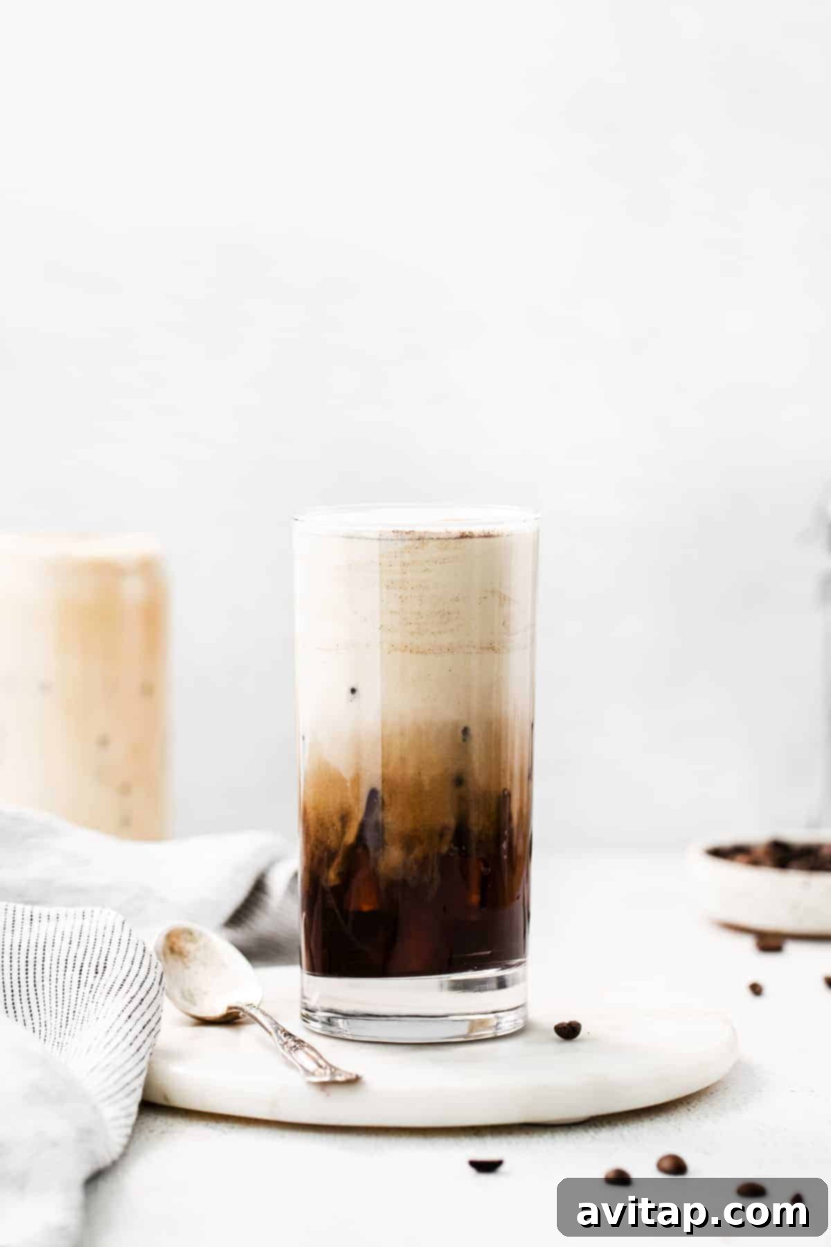 A tall glass of cold brew coffee topped generously with homemade vanilla sweet cream cold foam.