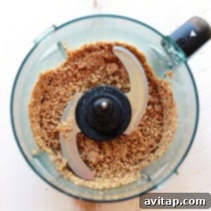 Almonds being processed into a fine meal in a food processor, essential for the base of cherry pie energy balls.